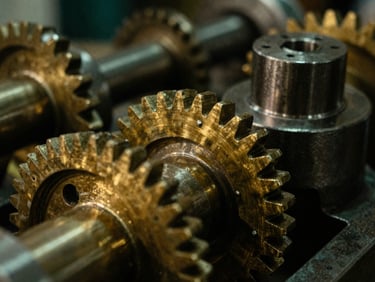 Macro close-up of heavy brass gears and machined steel components inside a quiet workshop, dramatic side lighting, rich shadows