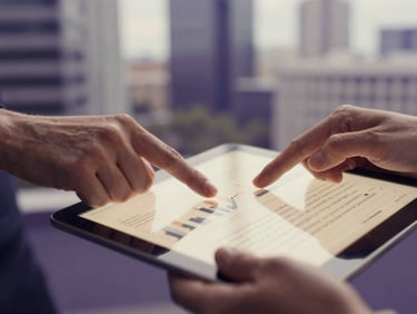 Close-up of hands reviewing a complex financial report on a tablet, with blurred modern office architecture in the background, soft natural daylight, deep purple and warm parchment tones, shallow depth of field, 35mm