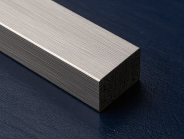 Close-up macro of premium materials, brushed steel resting against dark navy lacquered wood, sharp geometric lines, hard side light.