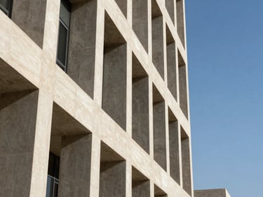 Architectural detail of a modern corporate building in Muscat, sharp geometric concrete lines against a bright blue sky, high-contrast natural light.