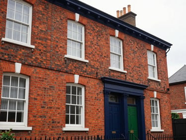 Architectural exterior of a classic red-brick UK Victorian terraced house, refurbished, clean windows, soft overcast daylight
