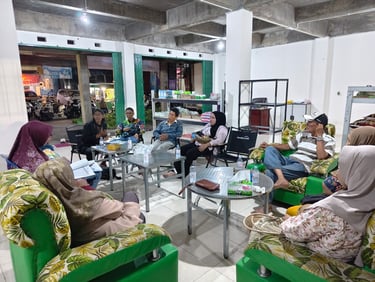 Community members gather for a formal meeting in a brightly lit room with green floral sofas.