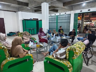 Community members holding a formal neighborhood meeting in a large room with green patterned chairs.