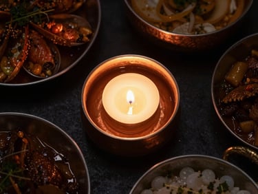 Overhead flat-lay of an opulent Indian banquet spread, copper bowls, flickering candlelight, rich textures, dramatic dark-mood food photography.