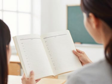 bright educational photography of a teacher reviewing a guide in a bright classroom, soft focus