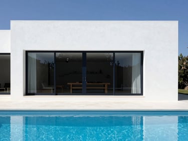 Minimalist luxury villa exterior in Quinta do Lago, white concrete architecture, clean blue pool, crisp shadows, bright daylight, 35mm