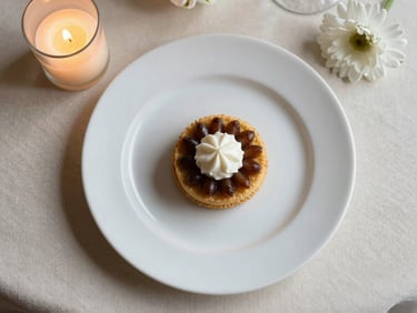 Overhead flatlay of an elegantly plated wedding course on fine bone china, ivory linens, single white flower detail at the plate edge, warm candlelight from the left, no people
