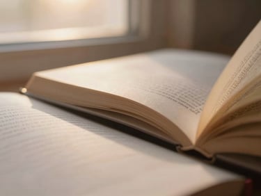 Close-up of book pages with soft-focus edges, warm golden-hour light filtering through a window, shallow depth of field