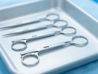 Close-up of sterile surgical blades arranged in a neat row on a sterile tray, bright clinical lighting, cool blue tones