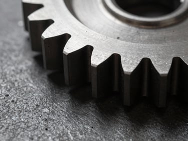 Macro shot of a laser-cut stainless steel gear edge, showing clean metallic texture and sharp corners, dramatic workshop shadows, 35mm
