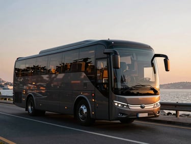 A modern luxury tour bus driving smoothly along the coastal road of Istanbul, sunset reflections on the windows, 35mm.