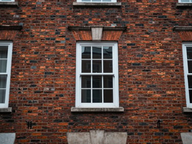 Straight-on architectural detail of restored 1840s brick townhouse exterior, natural overcast daylight, focusing on masonry texture