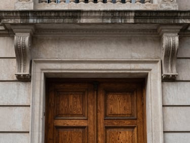 Limestone brownstone entry detail, carved stone lintels, heavy oak double doors, soft overcast daylight