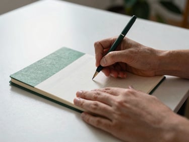 Medium shot of hands sketching a content calendar on a minimalist desk, soft natural light, forest green notebook, shallow depth of field, authentic agency moment, 35mm.