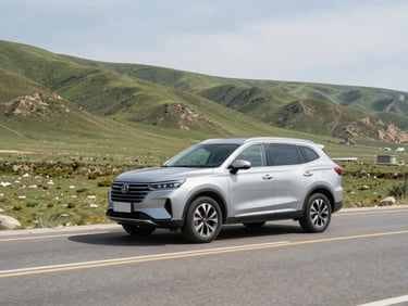 A clean silver SUV driving along the scenic Hazara Motorway surrounded by green hills, bright natural daylight, wide-angle environmental framing.