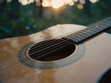 Extreme close-up of acoustic guitar strings and weathered wood, warm golden hour light through leaves, cinematic film grain, 35mm lens