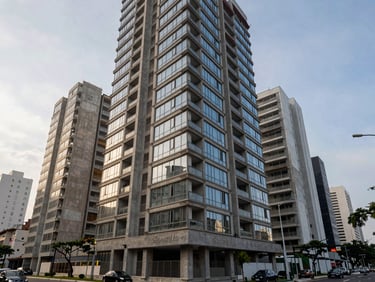 Wide environmental shot of a completed mid-rise residential building in São Paulo, concrete and glass façade, early morning overcast light, street level showing scale, no residents visible