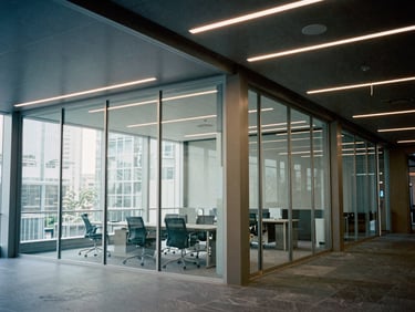 Modern commercial office interior with sharp geometric lighting and glass partitions, architectural film photography