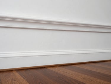 Bright interior shot of a living room with flawless white crown molding and perfectly straight paint lines.