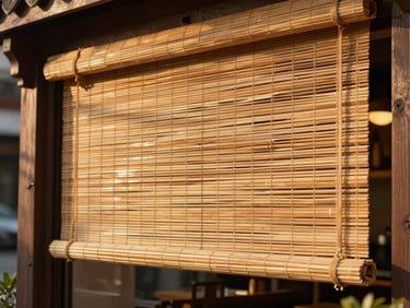 Close-up of a heavy-duty bamboo blind installed on an open-air restaurant facade, thick woven borders, warm afternoon sun filtering through.