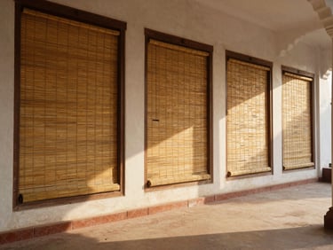 A wide shot of a beautifully shaded Lucknow verandah with hand-woven bamboo blinds installed, casting soft golden shadows on the tiled floor.