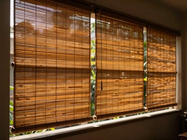 A beautiful, airy residential verandah in Hazratganj shaded by rich ochre bamboo blinds, soft green plants in the background.