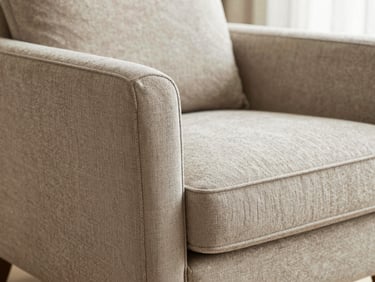Close-up of a beautifully upholstered armchair in a luxury residential setting, tactile fabric texture, shallow depth of field.
