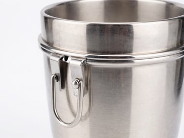 Close-up of a heavy-duty stainless steel mixer grinder jar with durable safety locks, bright high-key studio lighting, metallic reflections