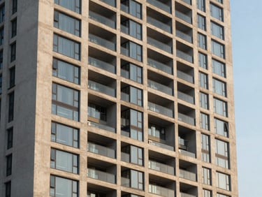 Modern high-rise residential facade along Dwarka Expressway, clean concrete and structural glass under high-contrast golden hour light.