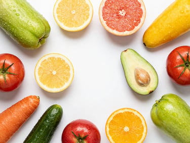 Overhead flat-lay of vibrant sliced fruits and dew-kissed whole vegetables on a clean white background, vibrant saturated natural colors