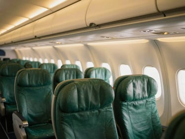 Interior of a modern commercial airplane cabin, spacious seating, warm ambient light