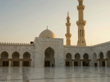 Serene white marble arches and minarets of the Prophet's Mosque in Madinah, soft dawn light