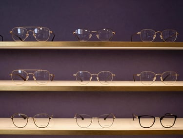 Elegant glasses display in Armazém store, minimalist design, golden accents.