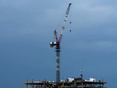 Marine construction crane against an overcast sky, coastal infrastructure, deep blues and steel grays, wide environmental shot, sharp details.
