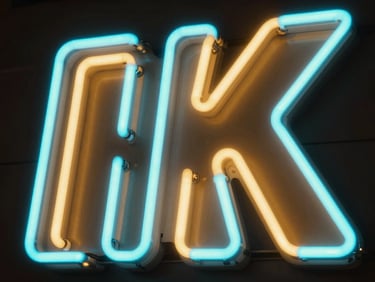 Close-up of vibrant cyan and amber LED neon flex letters glowing intensely in a dark room, sharp clean edges, no hot spots.