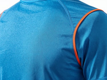 Close-up of premium athletic gear texture, electric blue fabric with stitching details, bright studio lighting, technical macro shot