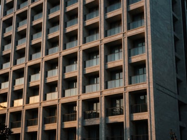 Architectural detail of a luxury resort facade, clean lines, golden hour light, reflecting precision and structure, cinematic editorial photography, golden-hour natural light, architectural composition.