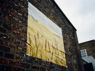 Low-angle gritty photo of a physical wheatpasting campaign on a brick wall in Shoreditch, high-contrast shadows, overcast daylight, 35mm film grain
