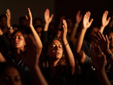 Passionate worshiper with raised hands in deep prayer, high-contrast dramatic lighting, deep shadows