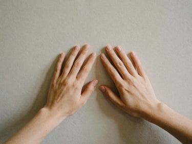 Two hands gently touching a textured surface, conveying connection and tactility, soft focus.