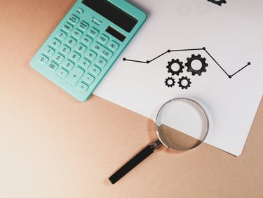 Analyse de données business représentés par une loupe, une calculatrice posées sur un graphique