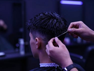 Macro shot of a stylist detailing a sharp haircut in a sleek dark salon, dramatic low-key neon lighting with deep indigo highlights, 35mm