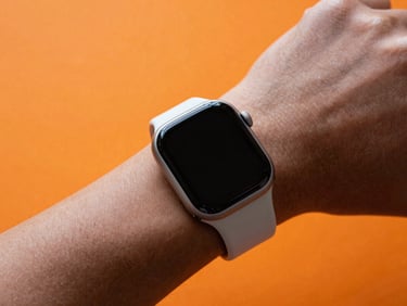 Close-up of a sleek minimalist smart watch on a wrist, vibrant orange background glow, high-key studio lighting