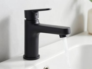 Close-up of a newly installed, modern matte black bathroom faucet with clean running water, bright natural daylight.