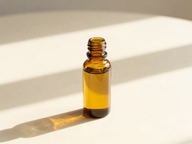 Amber glass bottle of golden seed oil catching soft morning sun on a cream table, minimalist editorial style