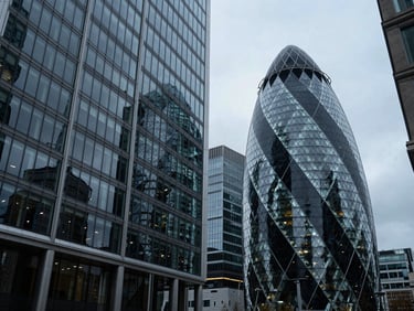 Wide-angle architectural perspective of a modern financial center in London, cool overcast daylight, sharp geometric glass reflections, deep blue and charcoal tones