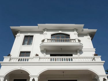 Low-angle architectural elevation of a three-story luxury villa in Bengaluru, crisp white stucco against deep blue sky.