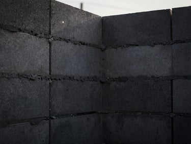 Close-up of neat masonry work, clean mortar lines on ceramic blocks, construction site, dramatic morning light
