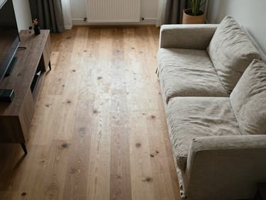 A beautifully styled studio apartment layout viewed from above, showing clear pathways, a low-profile linen sofa, and smart zoning.