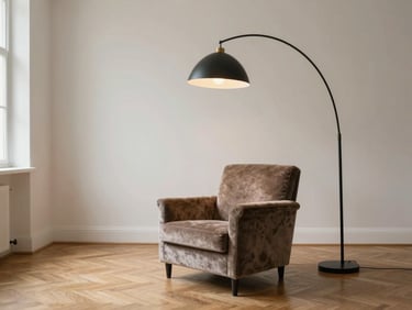 A spacious-looking studio apartment featuring one large, statement velvet armchair and a tall arched floor lamp, avoiding small cluttered furniture.
